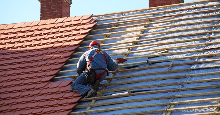 Sunnyside Roofing roofer working on a British tiled roof in Cheltenham